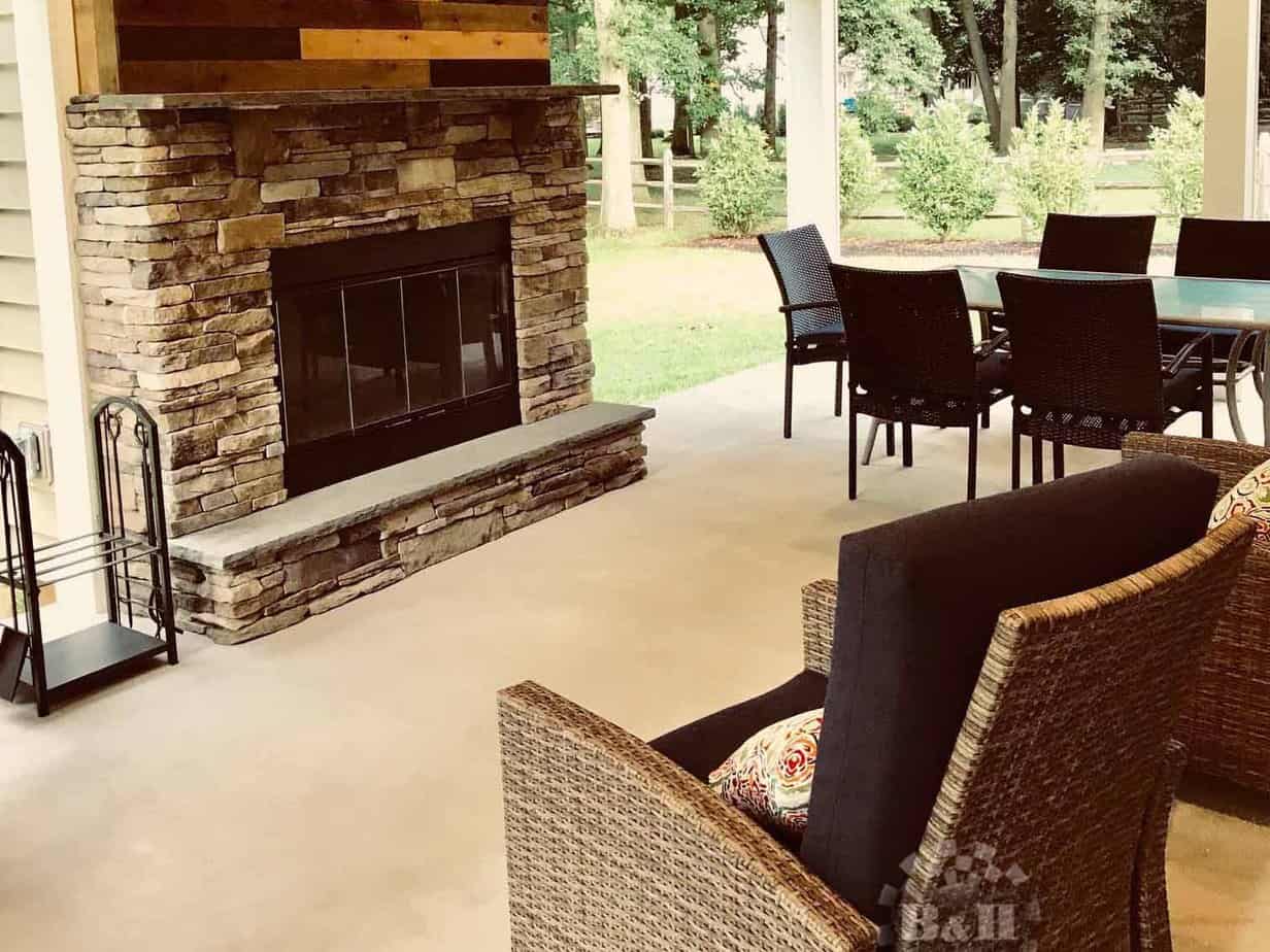 Refinished deck with fireplace and outdoor furniture.