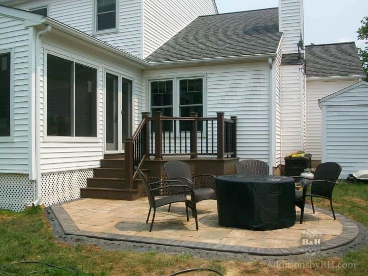 A finished deck, with a patio and fireplace, with our company logo.