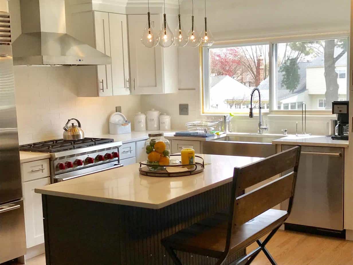A remodeled kitchen with a large island and stainless steel appliances.