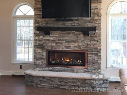 New stone fireplace with larges windows on both sides, with our logo.