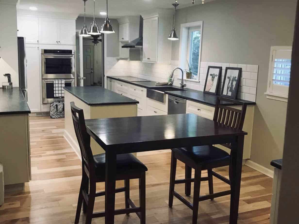 A finished kitchen with a black table and chairs.