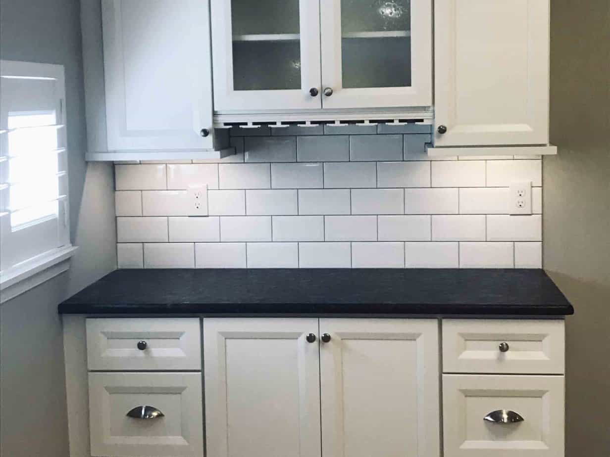 Refinished kitchen with white back splash.