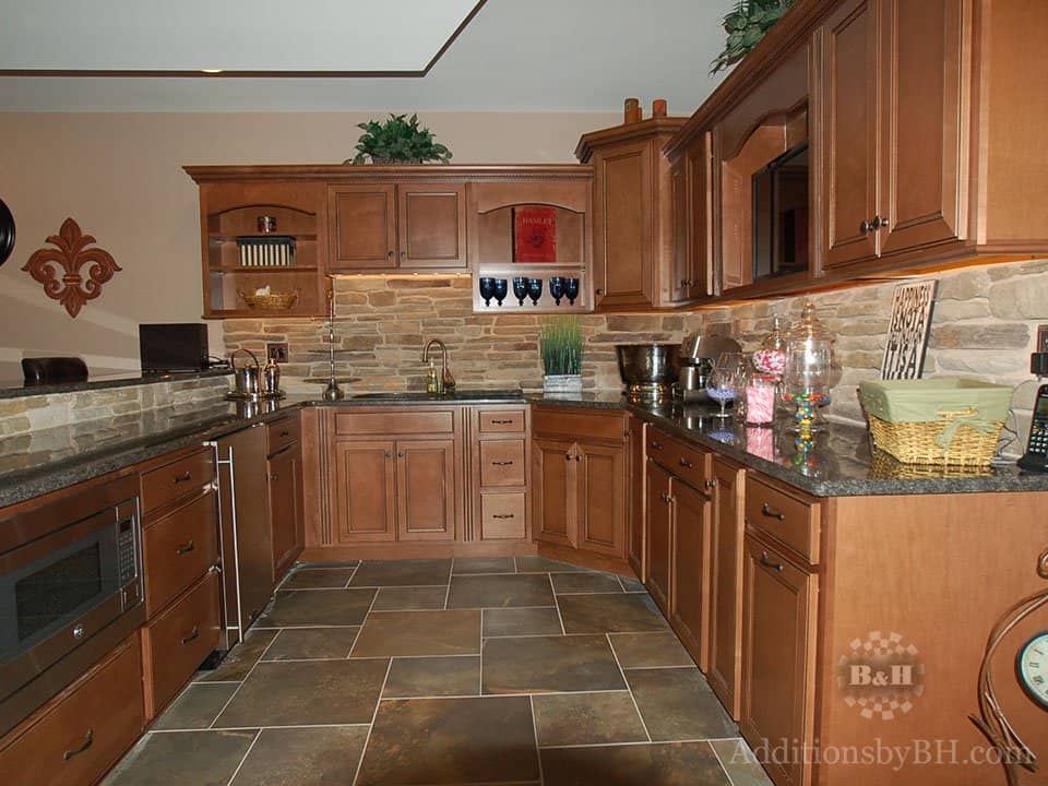 A kitchen with tile flooring, with our company logo.